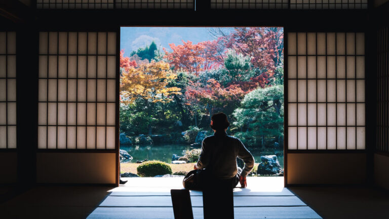 Persona sentada en la puerta de un cuarto de Japón. Hoteles con experiencias únicas en Japón